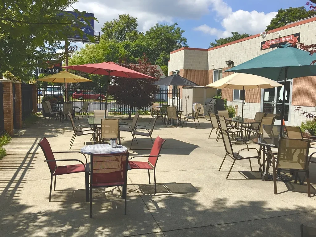 The Fulton Street Pub & Grill's empty outdoor patio with colorful umbrellas.