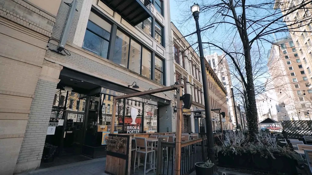 Urban restaurant Brick & Porter features patio with string lights, bare trees.