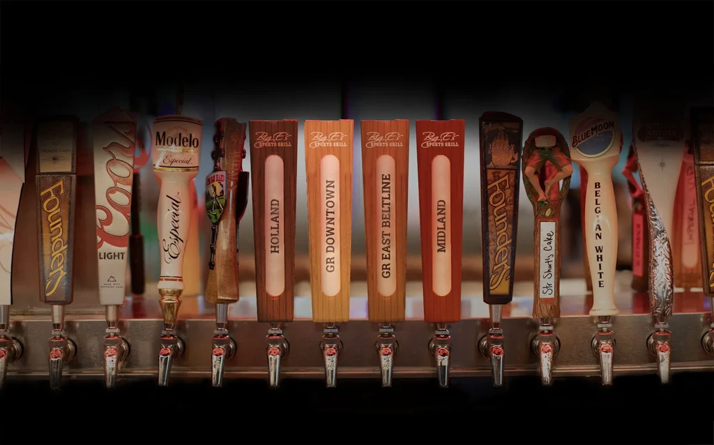 Close-up of 15-20 varied beer tap handles with distinct branding.