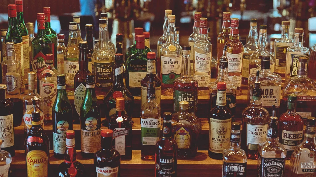 A wide array of liquor bottles displayed on tiered bar shelves.