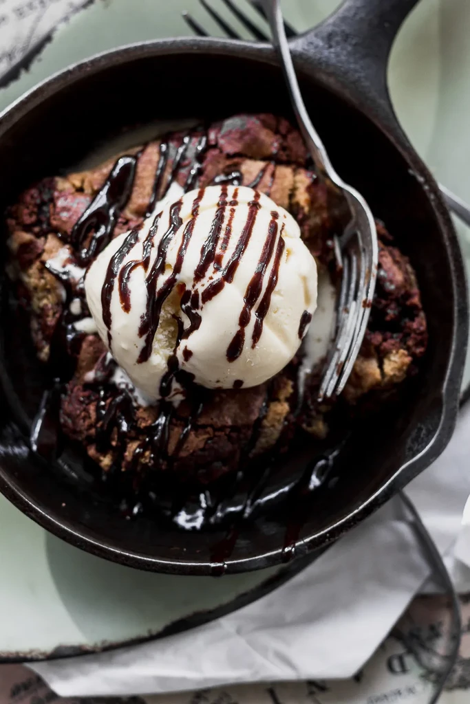 Warm skillet dessert with ice cream and chocolate sauce.