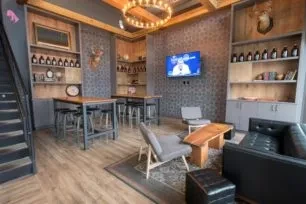 Empty modern rustic restaurant with varied seating and deer heads.