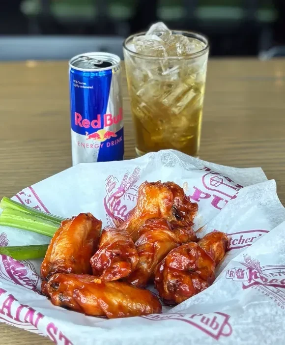 Saucy chicken wings, celery, Red Bull, and drink at University's Pub.