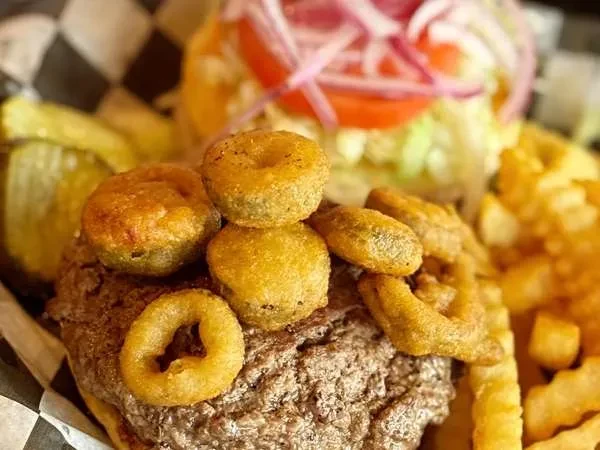 Burger with fried toppings, crinkle fries, and dill pickles.