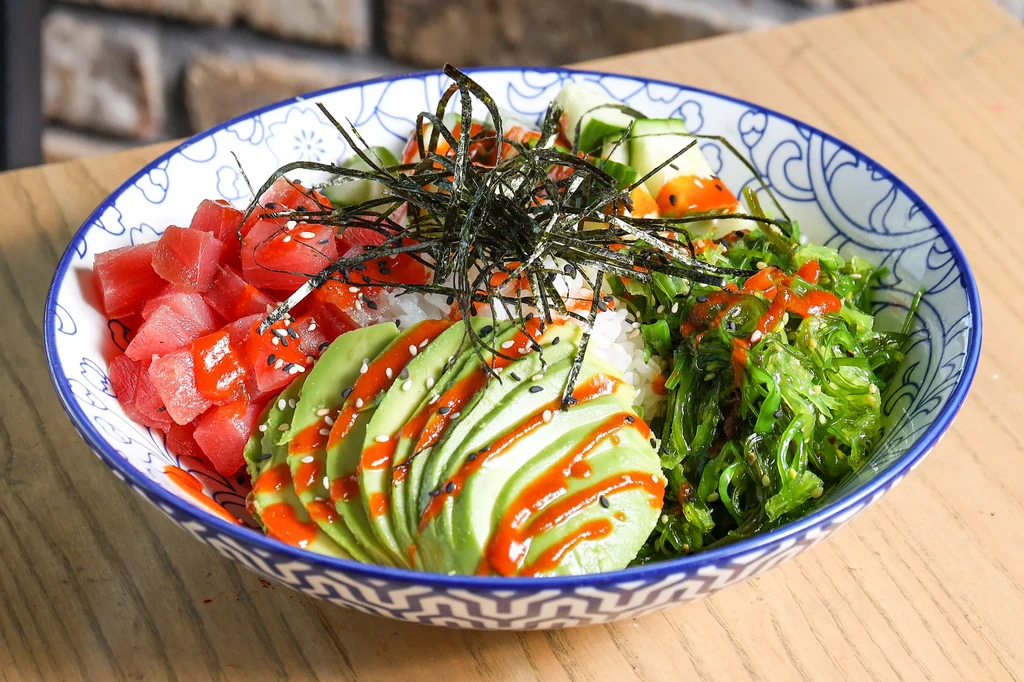 Poke bowl with tuna, avocado, rice, nori, and seaweed salad.