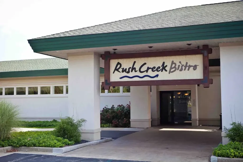 White Rush Creek Bistro building with green roof and hanging sign.