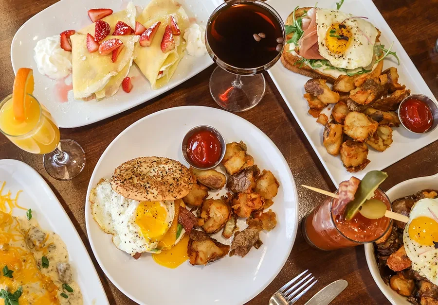 Overhead view of a table laden with breakfast and brunch dishes and drinks.