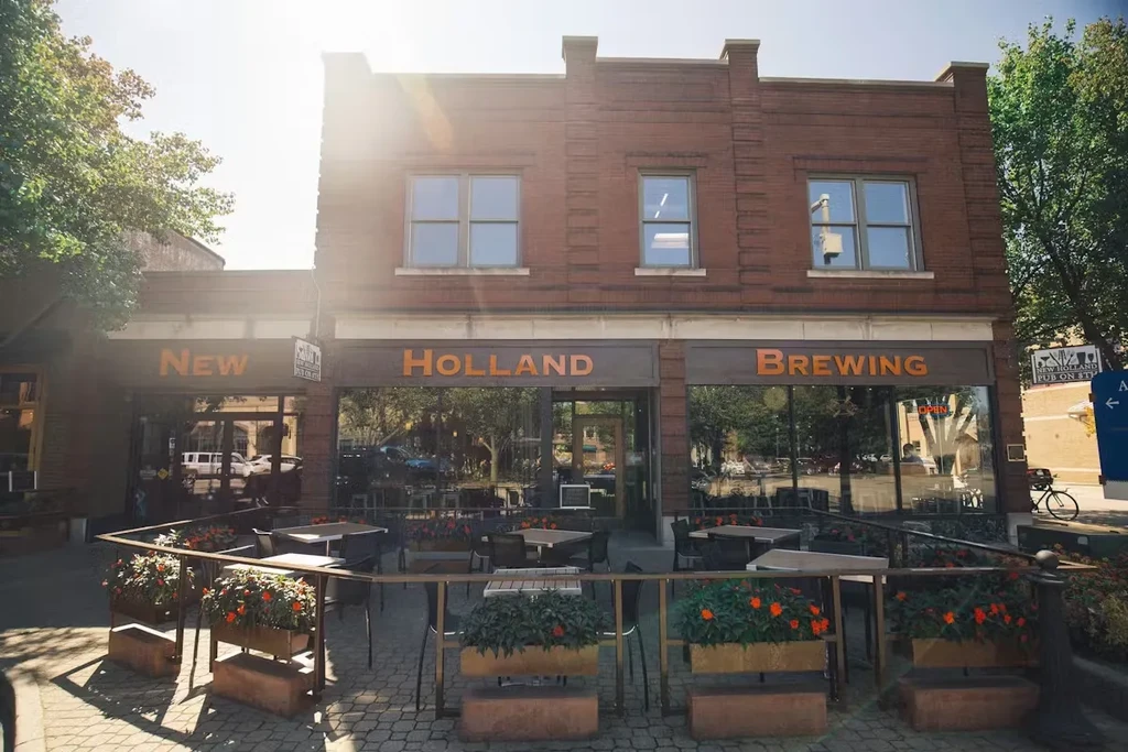 New Holland Brewing's brick storefront and sunny outdoor patio.