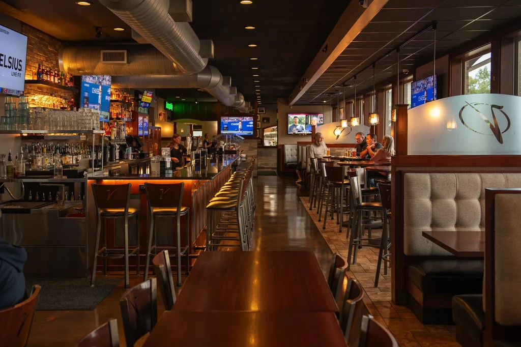 Modern industrial-chic restaurant and bar interior with patrons.