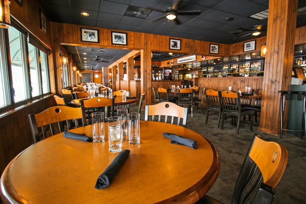 Empty rustic restaurant interior with warm wood and bar.
