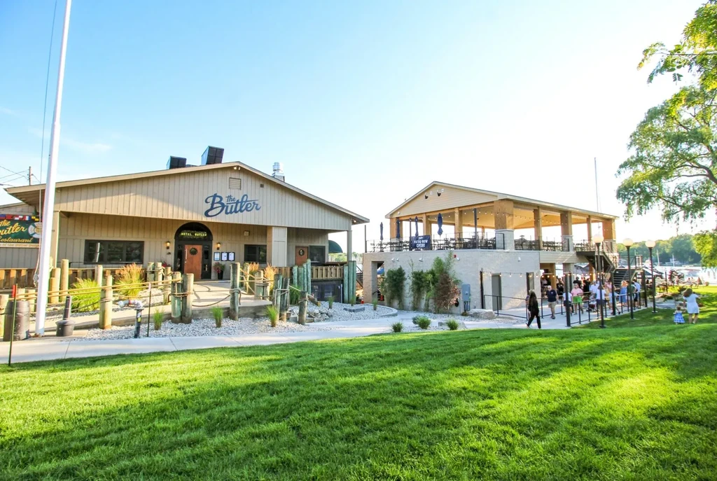 Sunny waterfront restaurant complex, The Butler, with many people.