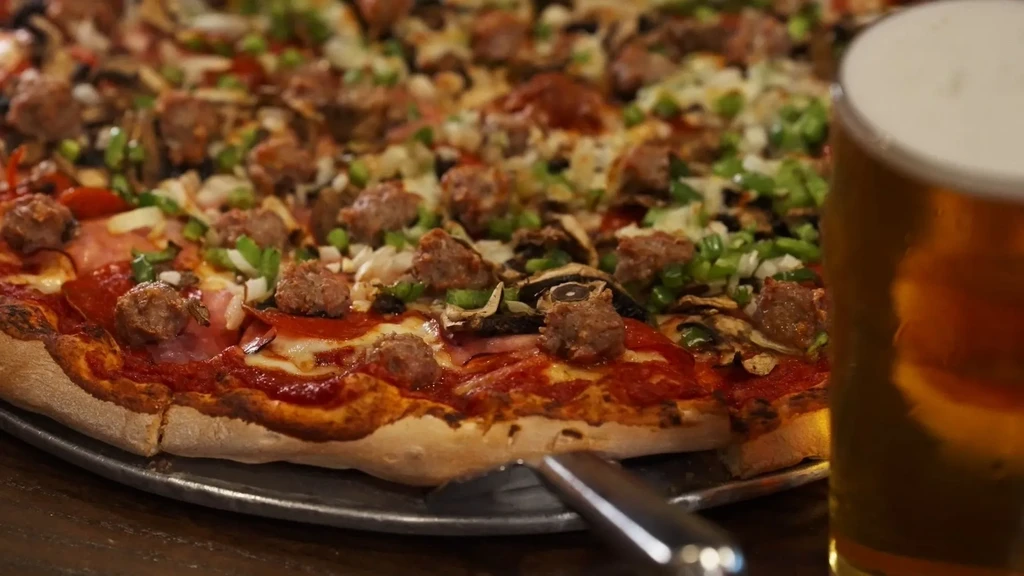 Large pizza with pepperoni, sausage, mushrooms, green onions, and beer.
