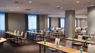 Professional multi-purpose room with rows of tables and sparkling water.