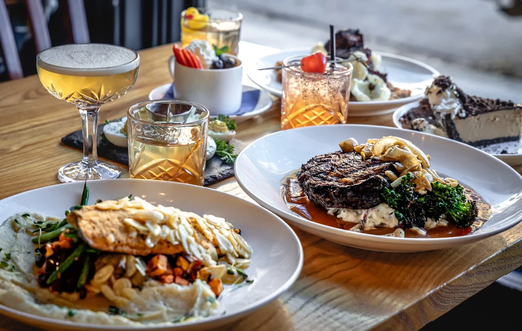 A spread of fish, steak, deviled eggs, cheesecake, and various cocktails.