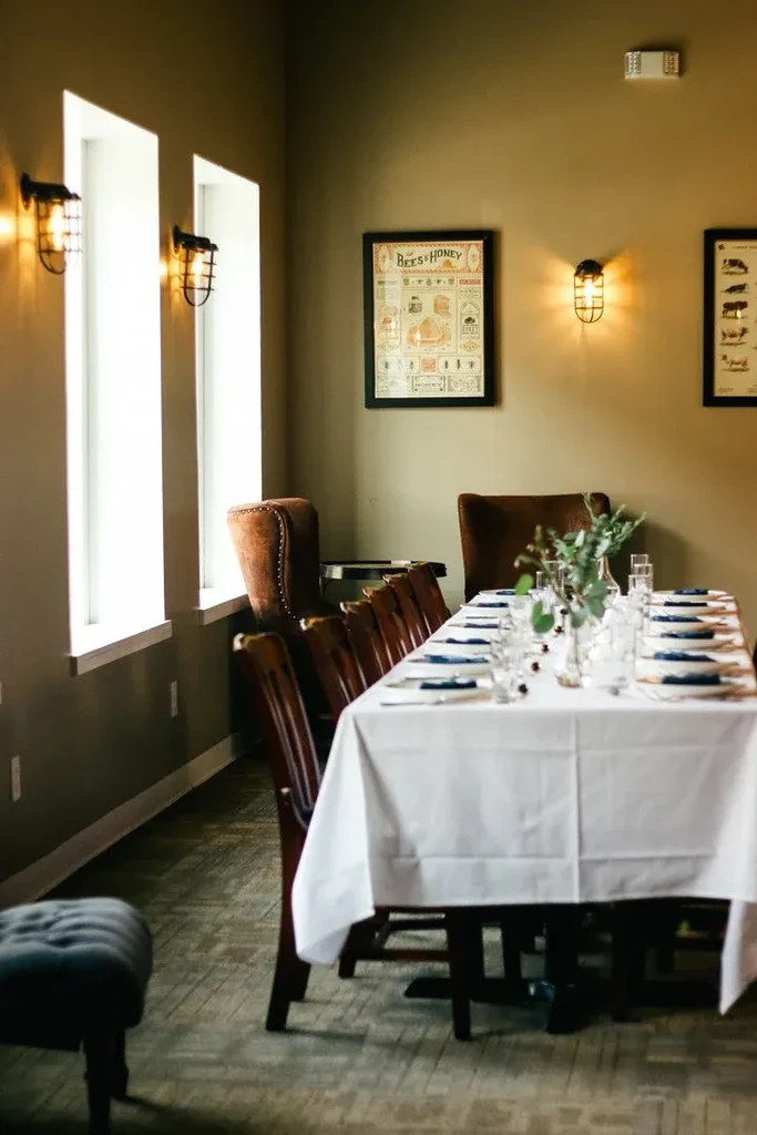 Elegant restaurant dining room featuring a long, meticulously set table.