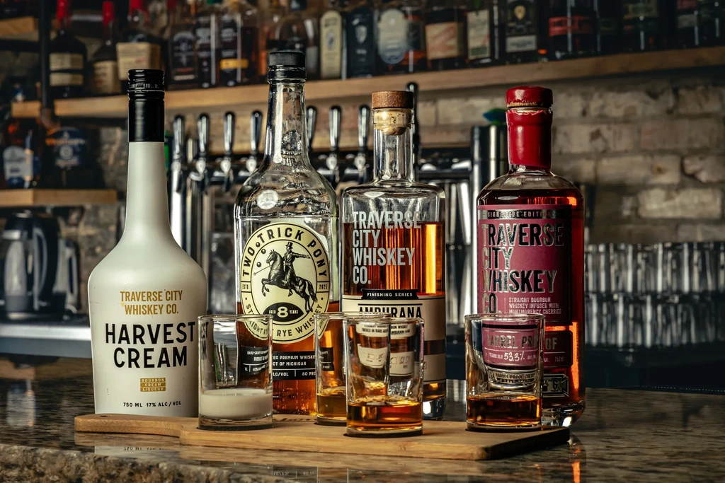 Traverse City Whiskey Co. bottles and shot glasses on a bar.