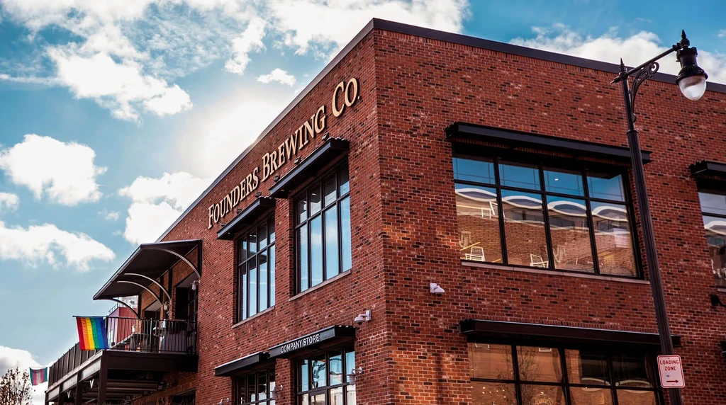 Exterior view of Founders Brewing Co. brick building with rainbow flag.
