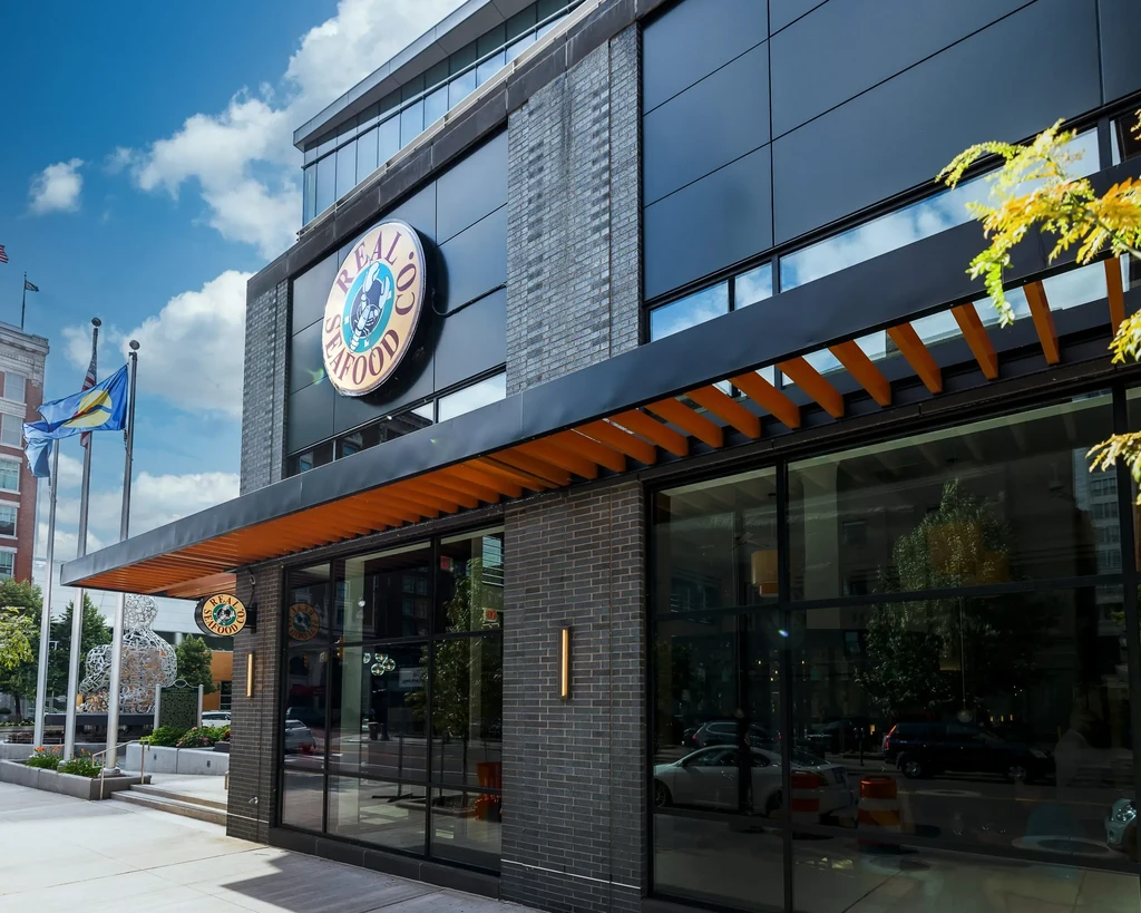 Modern Real O' Seafood restaurant building with sign and orange awning.