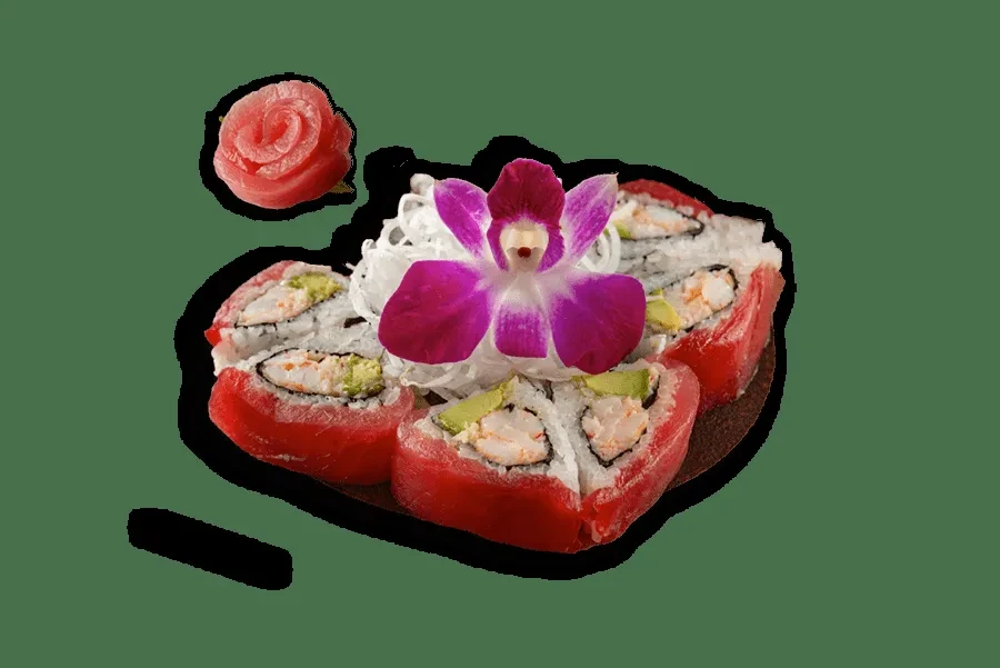 Intricately plated sushi, tuna, avocado, an orchid, and rose-shaped ginger.