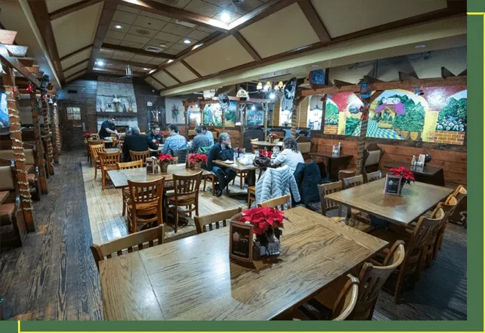 Rustic dining area with wooden furniture, murals, and poinsettia decor.
