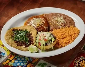 Mexican combo plate: taco, tostada, enchiladas, rice, and beans.