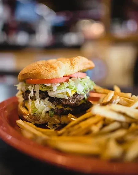 Double-patty burger with cheese, lettuce, tomato, and fries.