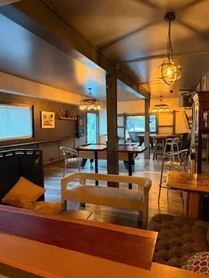 Dimly lit restaurant/bar interior with two pool tables and rustic decor.