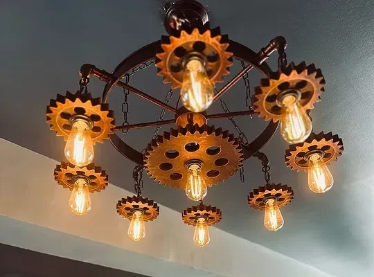 Industrial steampunk chandelier with gears, chains, and warm Edison bulbs.