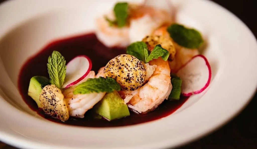 Cooked shrimp with purple sauce, mint, radish, avocado, and seeded cracker.