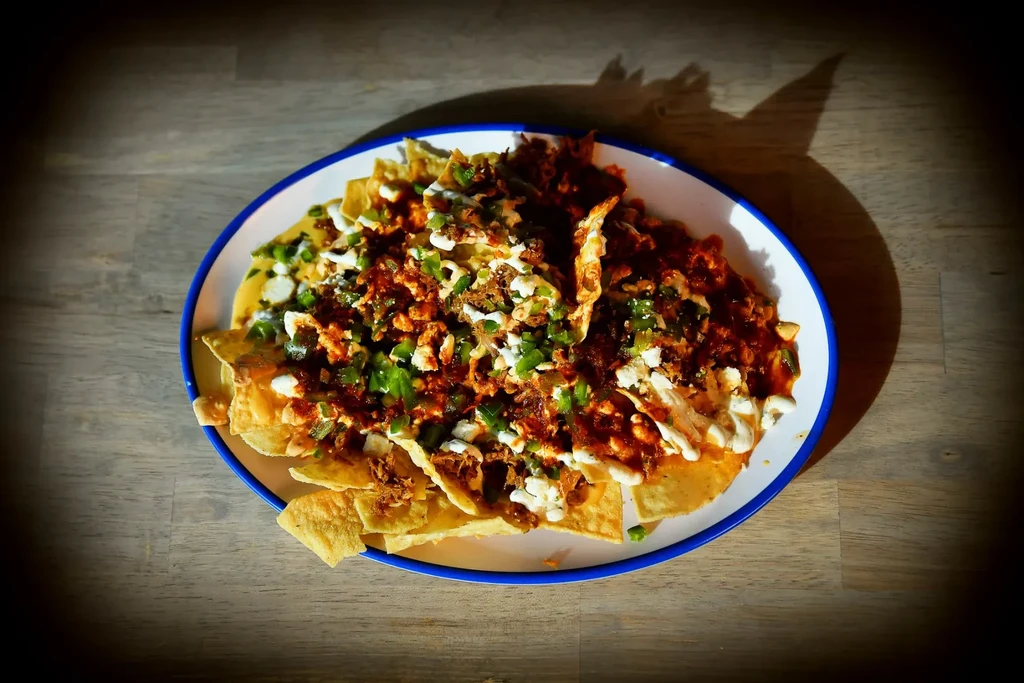 Fully loaded nachos with meat, melted cheese, cream, and jalapeños.