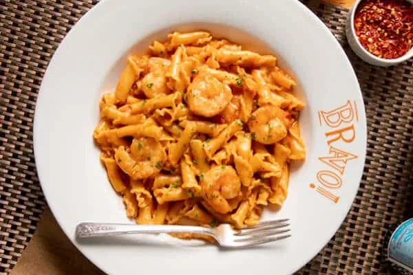 Penne pasta with shrimp in red sauce, "BRAVO!" plate.