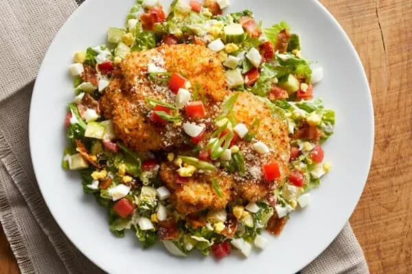 Fried chicken salad with eggs, bacon, cheese, and creamy dressing.