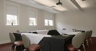 Empty meeting room: large hollow square table with black and white cloths.
