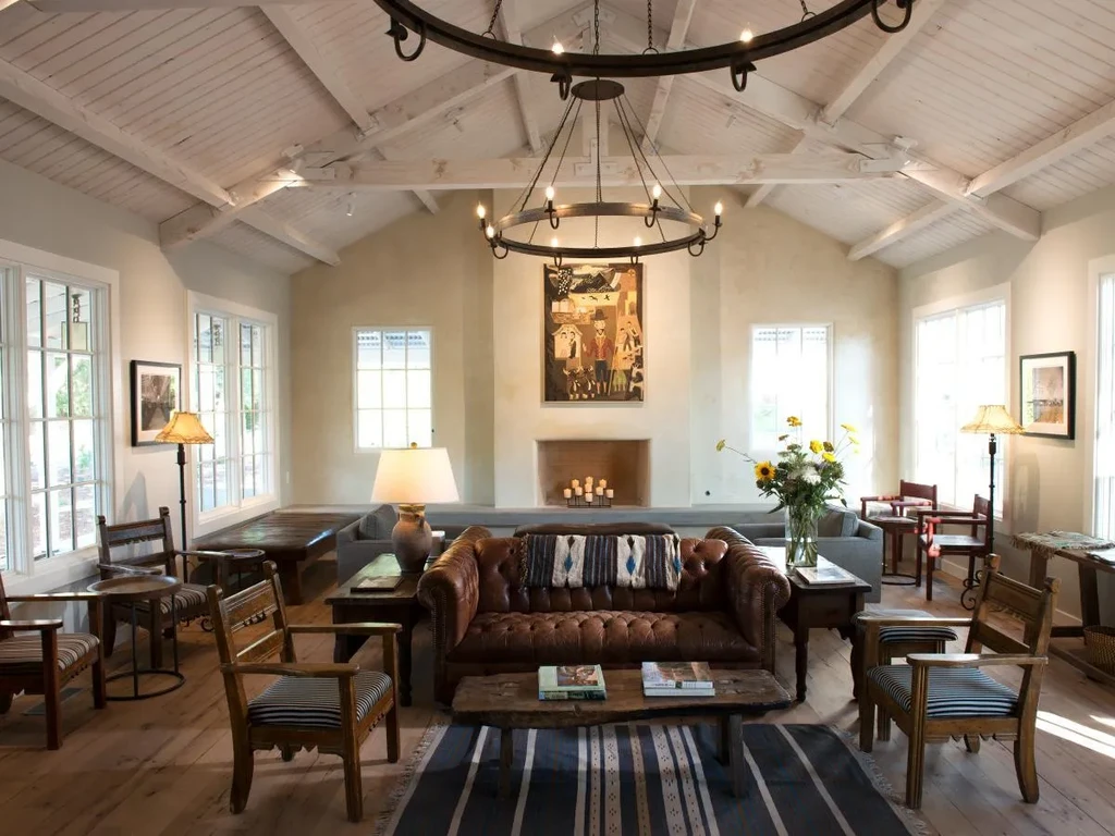 Spacious, rustic-chic lounge with vaulted ceiling, leather sofa, and fireplace.