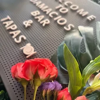 Bouquet of red roses and flowers before a welcome sign.