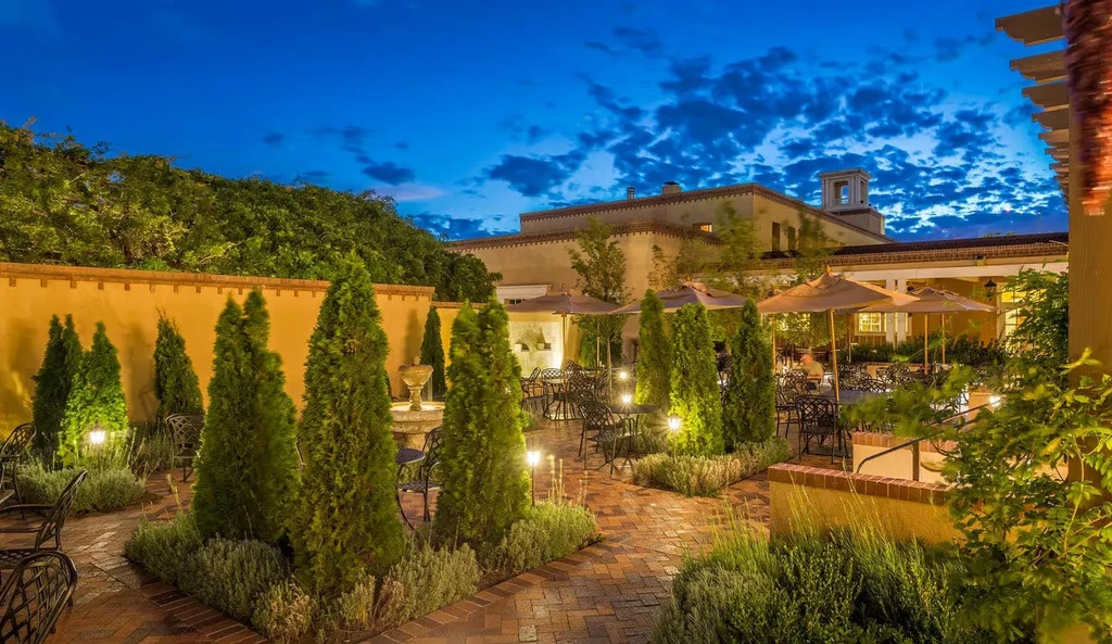 An elegantly lit outdoor restaurant courtyard at dusk.