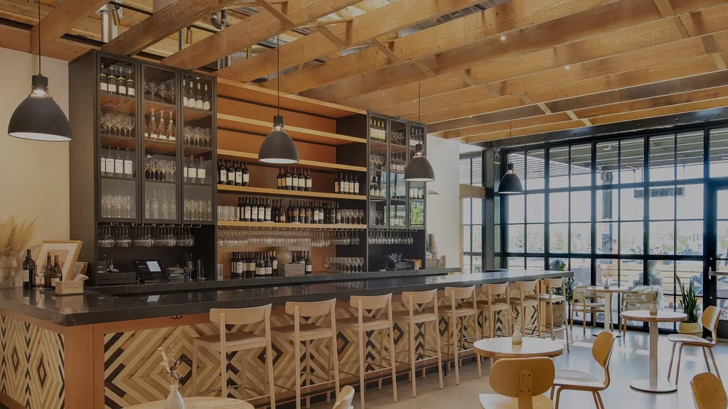 Empty modern restaurant bar with geometric wood and wine displays.