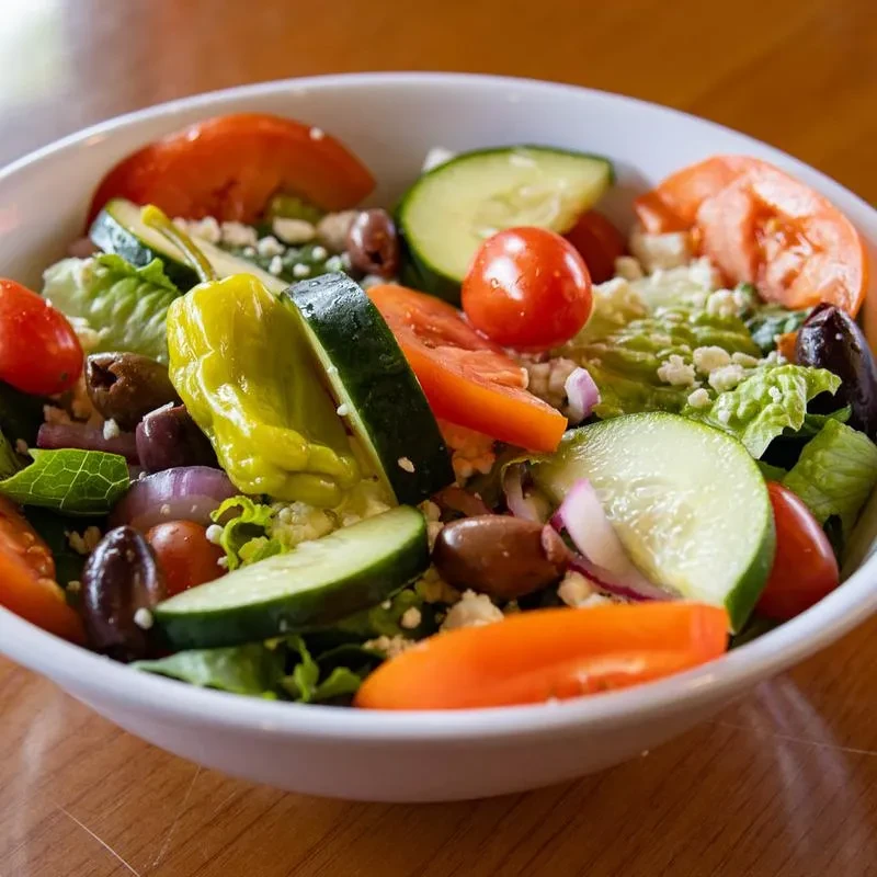 Colorful Greek-style salad with feta, olives, tomatoes, and pepperoncini.