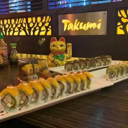 Sushi platters with Takumi sign and golden Maneki-neko.