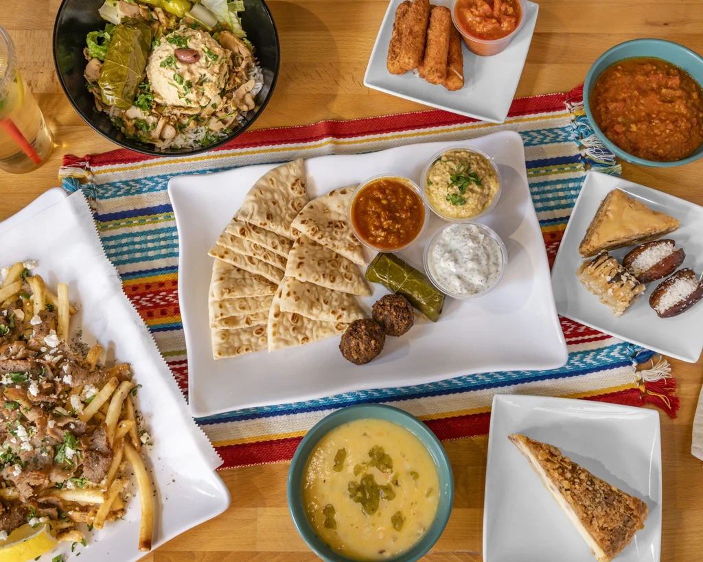 Overhead view: Table laden with diverse Mediterranean dishes and a drink.