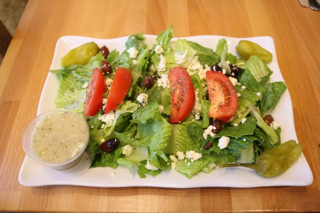 Greek salad with feta, olives, pepperoncini, and creamy dressing cup.