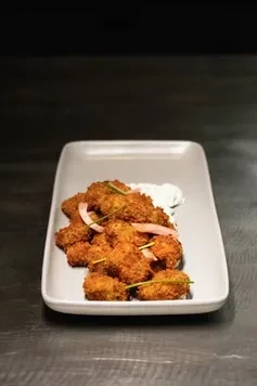 Fried fritters or chicken, pickled onions, and creamy white sauce.
