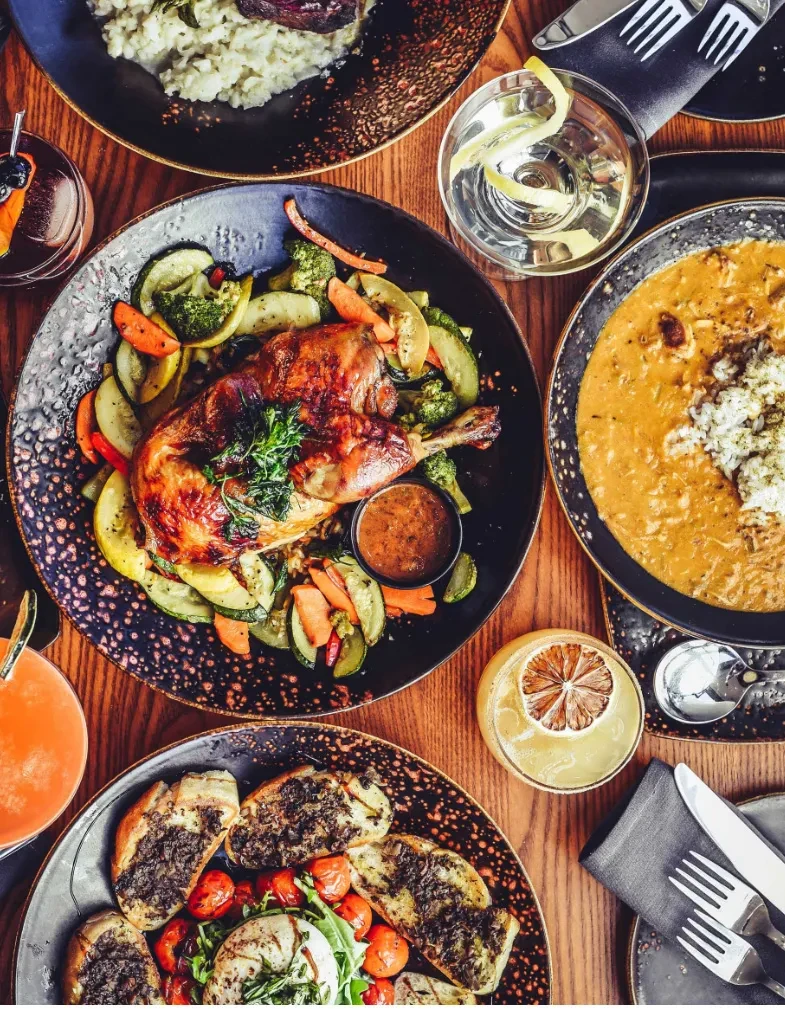 Top-down view of a table set with diverse, appealing dishes and drinks.