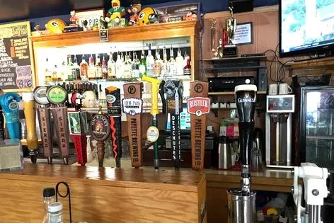Beer taps, liquor, and Packers memorabilia in a casual sports bar.