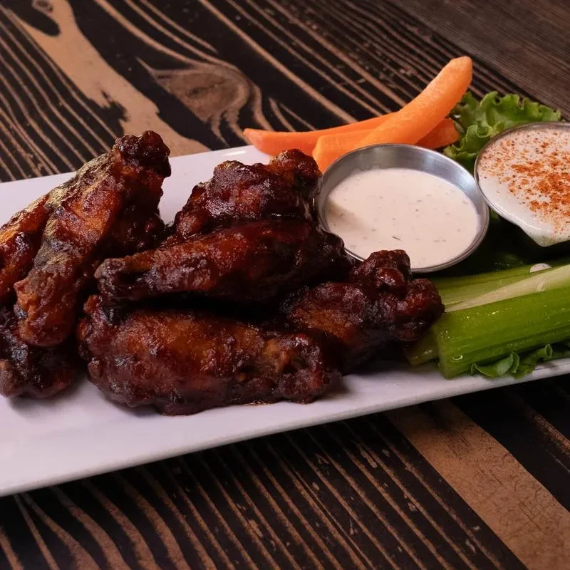 Glazed chicken wings, two creamy dips, celery, and carrot sticks.