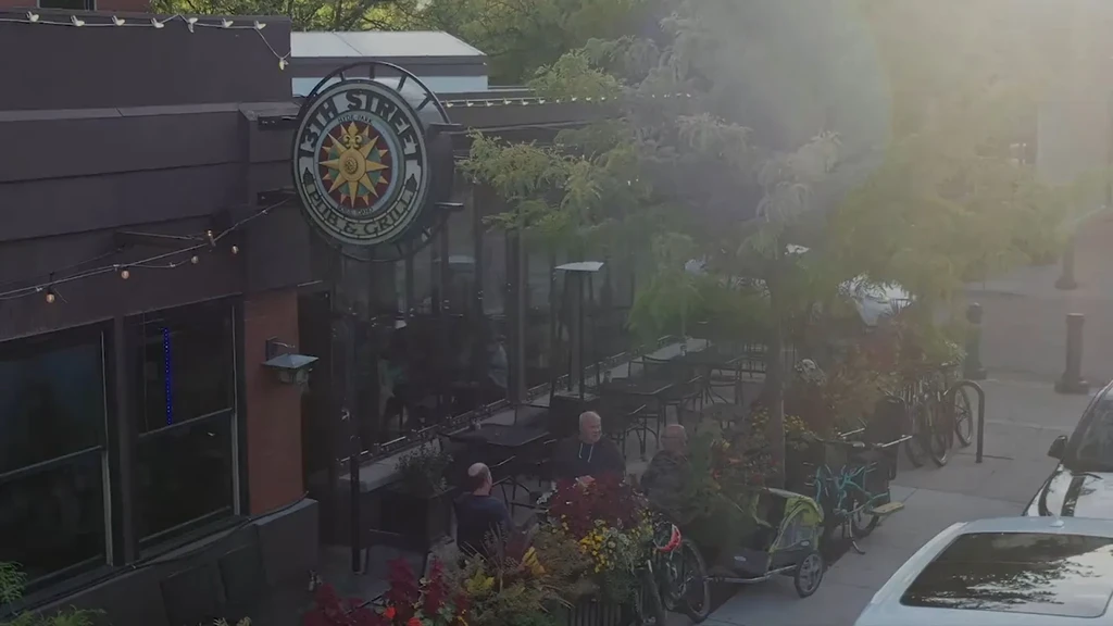 Exterior of 13th Street Pub & Grill, people dining on sunny patio.