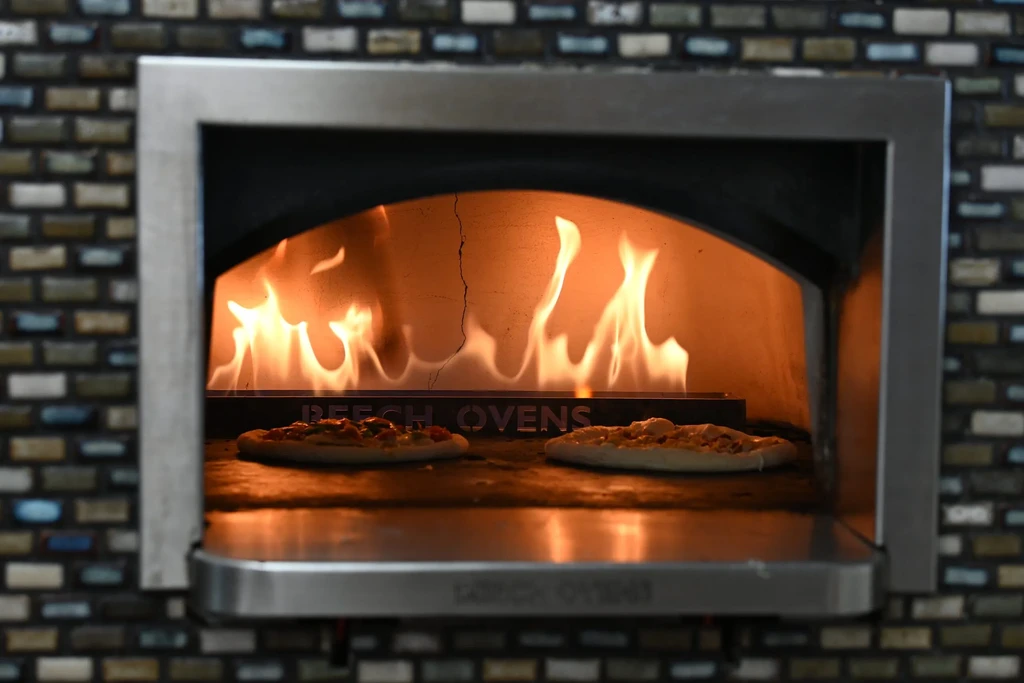 Two pizzas baking in a Beech Ovens wood-fired mosaic oven.