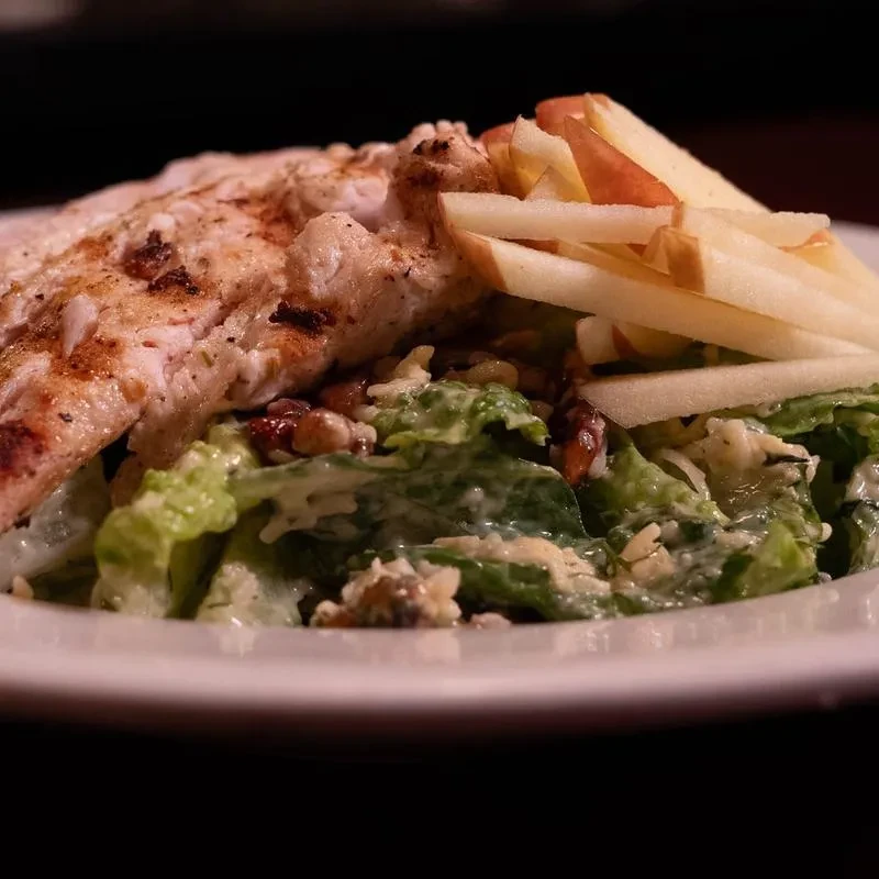 Grilled chicken salad with nuts, apples, and creamy dressing.