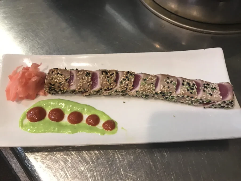 Medium-rare, sesame-crusted tuna with pickled ginger and two sauces.