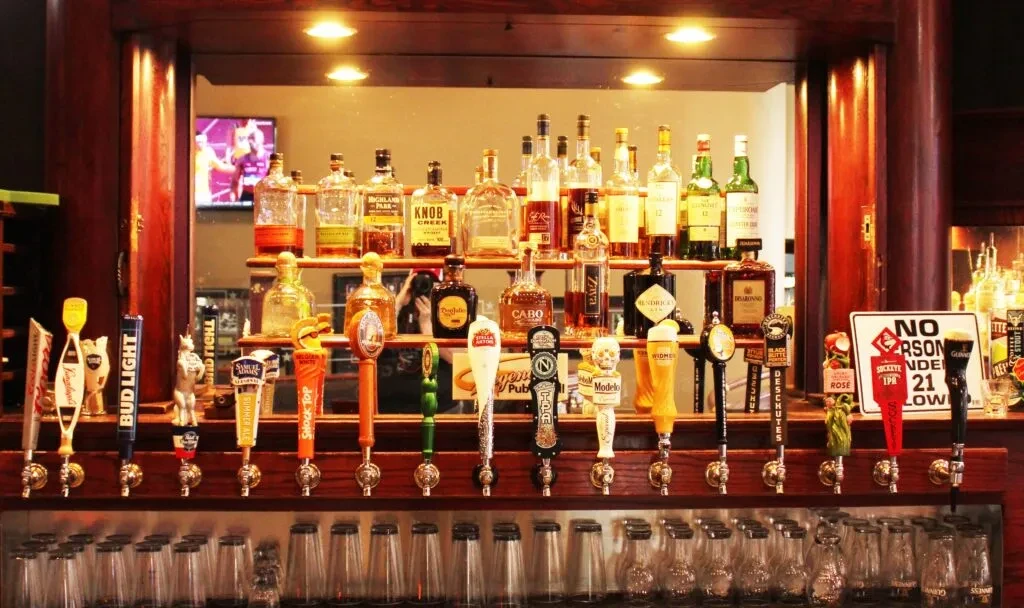 Well-stocked bar with many beer taps and liquor bottles.